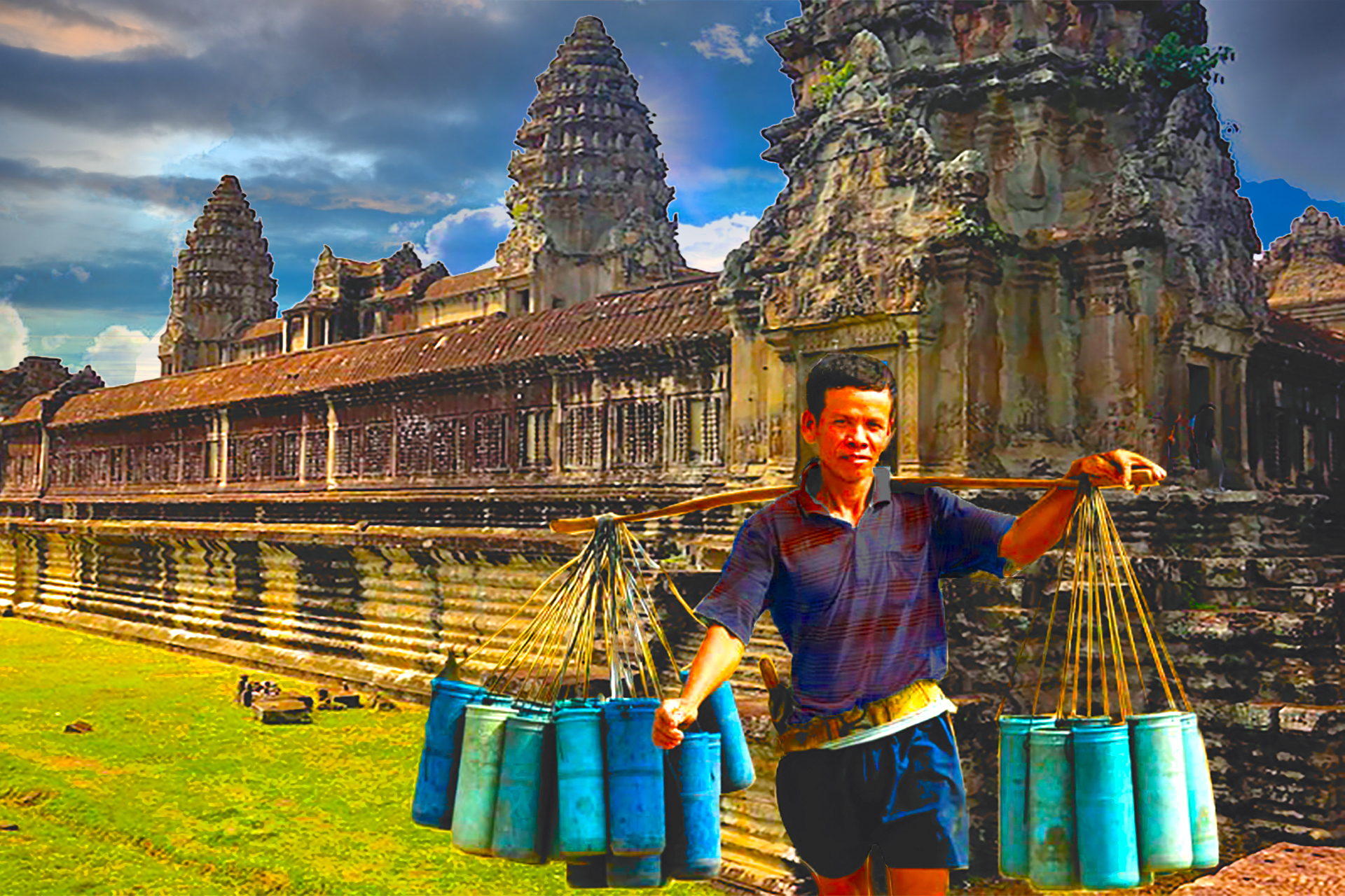 A man carrying a basket of blue cans, standing in front of the Angkor Wat temple complex in Cambodia with the sky in the background.